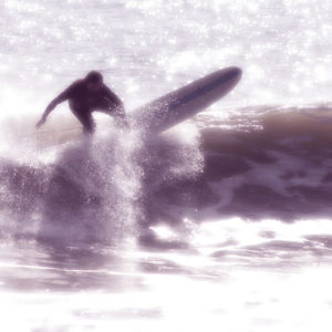 Photograph of Sebastian Aravena surfing and doing a floater on a longboard. Photograph by Colleen Aravena.